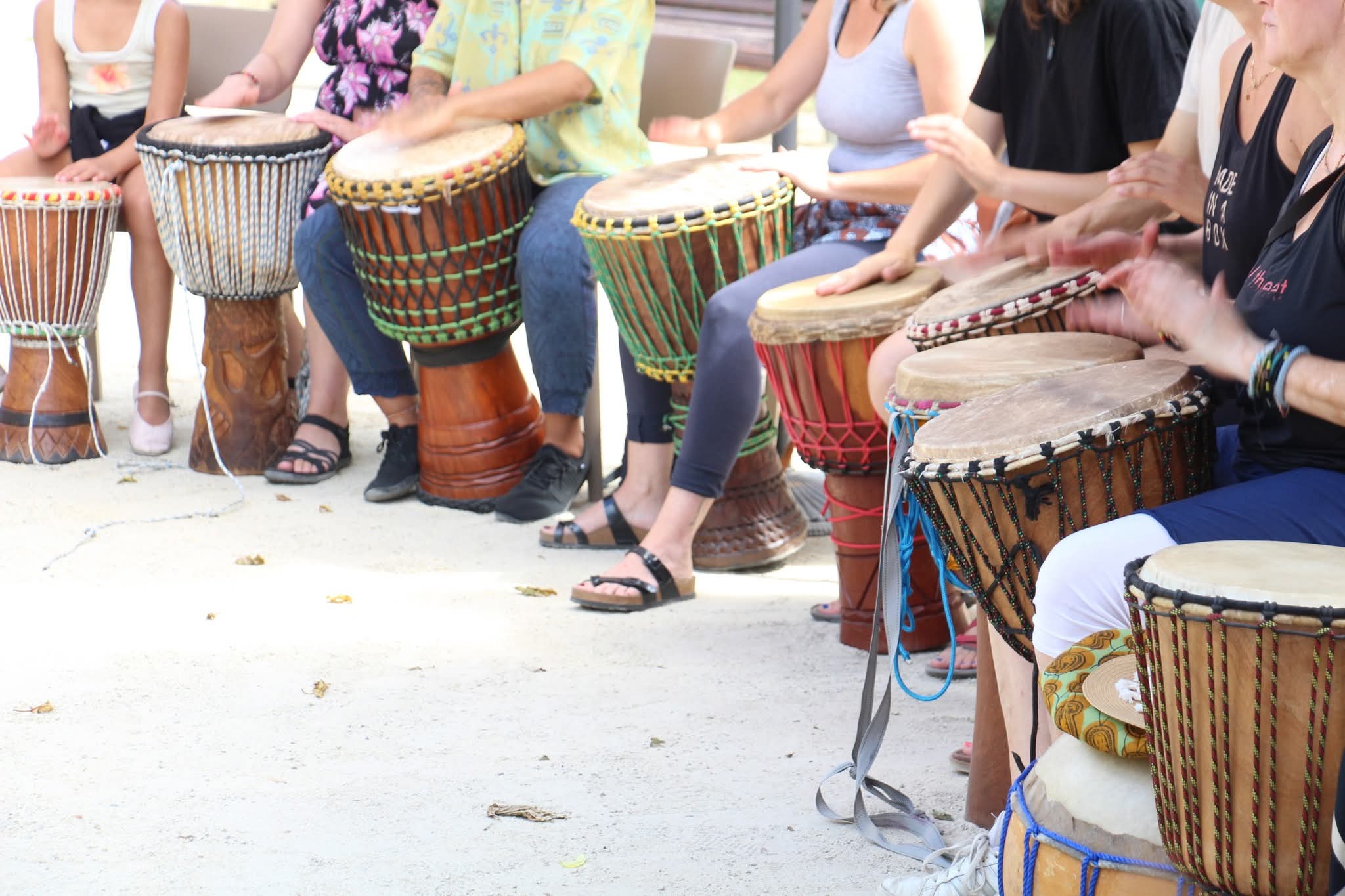 Rangée de djembés joués en cercle par des participant·es d'AKOFA ASBL